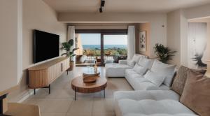 a living room with a white couch and a tv at Aerope SeaView Villa in Koutsounari +23 photos