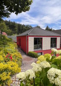 ein rotes und weißes Haus mit Blumen davor in der Unterkunft Ferienhaus Conradshöh in Ilmenau
