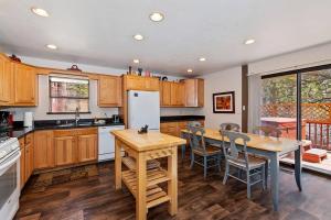 a kitchen with wooden cabinets and a table and chairs at Beautiful 3 BR Cabin/Great Views/Lots of Amenities in Big Bear Lake