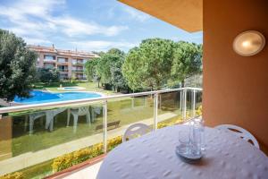 a table on a balcony with a view of a pool at Apartaments Sa Guilla in Pals