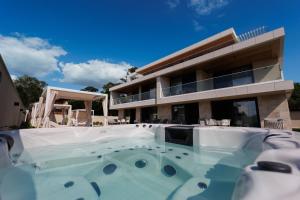 a house with a swimming pool in front of it at Gold Wave Apartments in Siófok