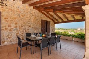 a dining room with a table and chairs on a patio at Villa Guillona in Alcudia