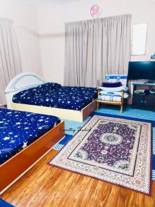 um quarto com duas camas e um tapete no chão em ROOMSTAY SHAHID HOU'ZE em Kangar