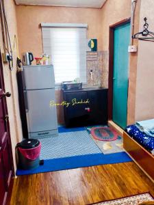 uma cozinha com um frigorífico e uma porta aberta em ROOMSTAY SHAHID HOU'ZE em Kangar