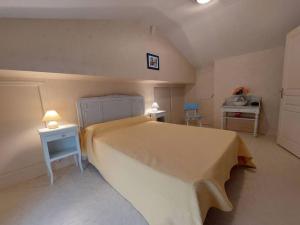 een slaapkamer met een groot bed en 2 tafels bij Gîte l'Ostalet de Sarron à Brax, Lot et Garonne in Brax