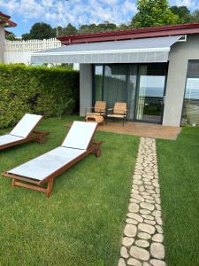 two beds on the grass in front of a house at Kabakum Holiday Houses in Golden Sands