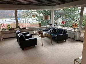 a living room with two couches and a table and windows at Schönes Zimmer in guter Lage in Aalen/Unterkochen in Unterkochen