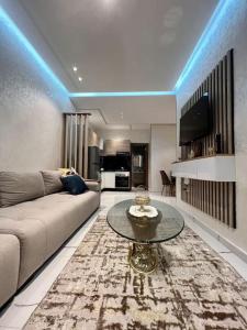 a living room with a couch and a table at Cozystay - Anchor of mehdia in Kenitra