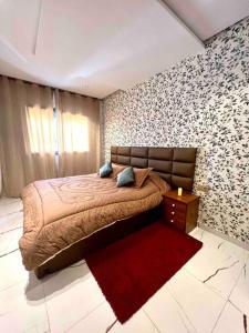 a bedroom with a bed and a red rug at Cozystay - Anchor of mehdia in Kenitra