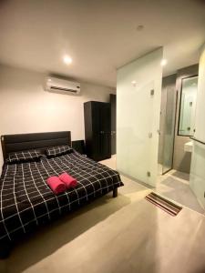 een slaapkamer met een bed met twee rode kussens erop bij Rehat Guest House, The Square, One City, USJ25 in Subang Jaya