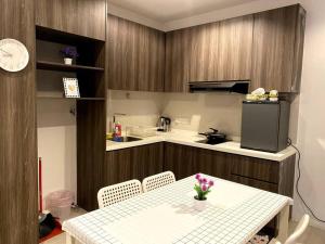 een keuken met een tafel met stoelen en een koelkast bij Rehat Guest House, The Square, One City, USJ25 in Subang Jaya