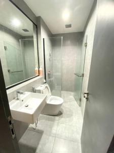 een badkamer met een wastafel, een toilet en een spiegel bij Rehat Guest House, The Square, One City, USJ25 in Subang Jaya