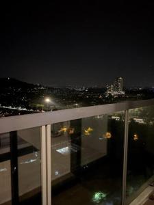 een balkon met uitzicht op de stad 's nachts bij Rehat Guest House, The Square, One City, USJ25 in Subang Jaya