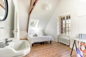 een badkamer met een wastafel en een bed in een kamer bij Le Cottage - Maison avec vue imprenable in Saint-Cast-le-Guildo