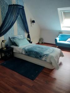 シュットルフにあるHaus Drosselのベッドルーム1室(青い天蓋付きのベッド1台付)