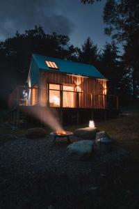 a cabin with a fire in front of it at night at Mertrick in Forest Mill