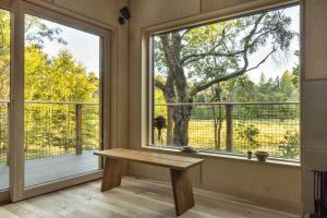 Habitación con banco frente a una ventana grande. en Mertrick en Forest Mill