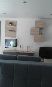 a living room with blue chairs and a flat screen tv at Kleines Landhaus in Stromberg