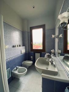 uma casa de banho azul com um lavatório e um WC em La Casina di Nonno Enzo em Vinci