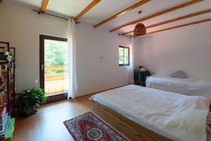 1 Schlafzimmer mit 2 Betten und einem Fenster in der Unterkunft Susurul Apei Chalet in Porumbacu de Sus