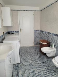 a bathroom with two sinks and a toilet and a door at Italian style Apartment in Durrës +30 photos