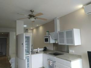 uma cozinha com armários brancos e uma ventoinha de tecto em Estudio al lado de la Playa em Fuengirola