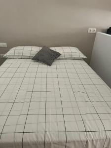 ein weißes Bett mit zwei Kissen darüber in der Unterkunft Estudio al lado de la Playa in Fuengirola