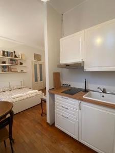een keuken met witte kasten en een bed in een kamer bij Città Studi Apartment in Milaan