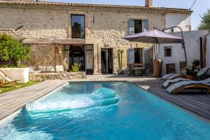 une piscine en face d'une maison avec un gonflable dans l'établissement Mas Lafleur, à Châteaurenard