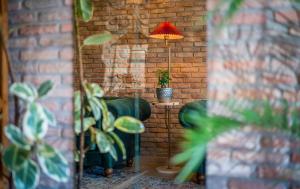 a living room with a couch and a lamp in a brick wall at Twentyone By Vintage Hotel Collections in Tbilisi City