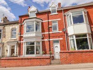 a red brick house with white windows at 12 Westfield Terrace in Saltburn-by-the-Sea