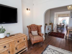 a living room with a chair and a flat screen tv at 12 Westfield Terrace in Saltburn-by-the-Sea
