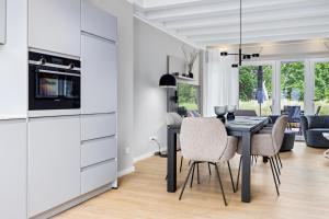 ビンツにあるStrandresidenzen Binz-Prora Strandresidenzen Binz-Prora D0 1のテーブルと椅子のあるキッチンとダイニングルーム