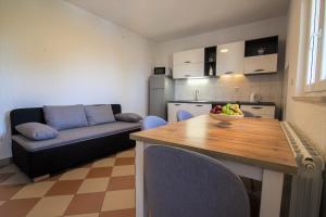a kitchen and living room with a table and a couch at Apartments Teskera in Bol