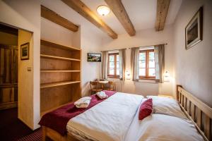 1 dormitorio con 1 cama con 2 toallas en Pivovar Lyer, en Modrava