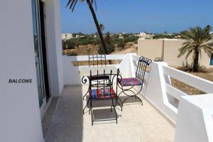 Un balcón con sillas y vistas al océano. en Appartement MANEL, en Mezraya