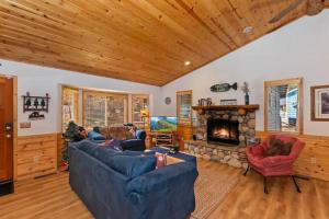 sala de estar con sofá azul y chimenea en Cozy Adorable Cabin / Scenic Outdoor dining area en Big Bear City