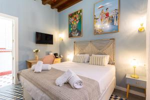 1 dormitorio con 1 cama grande y toallas. en Casa de Alma, en Málaga