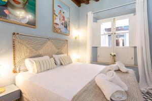 una camera da letto con un grande letto bianco con asciugamani di Casa de Alma a Málaga