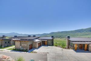 an aerial view of a building with mountains in the background at Powder Mountain Home with Private Hot Tub and Views! in Eden