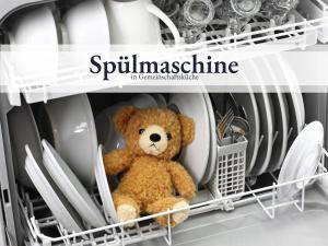 a teddy bear sitting in a dishwasher at Blumenvilla 2 mit begehbarer Dusche, Sauna, Garten in Schneverdingen +6 photos