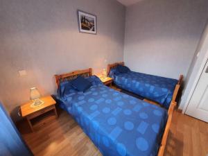2 Betten in einem Zimmer mit einem Tisch und 2 Lampen in der Unterkunft Location à Lannes - Clévacances 3 clés in Lannes