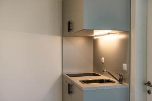 a small kitchen with a sink and a light at Hostel 'SD Palacin' in Šibenik