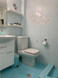 a white bathroom with a toilet and a sink at Blue Maison in Paralia Katerinis