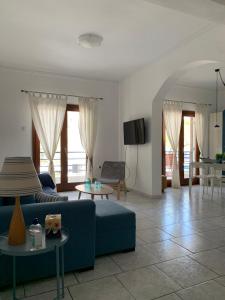 a living room with a blue couch and a table at Blue Maison in Paralia Katerinis