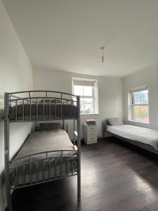 a bedroom with two bunk beds and two windows at Sarsfield Hostel in Dublin