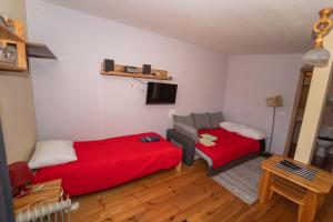 a small room with two beds and a tv at Biesy2 in Wetlina