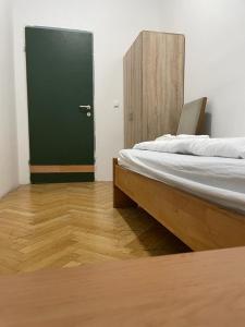 um quarto com uma cama e uma porta verde em easybook-in em Viena