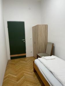 um pequeno quarto com uma cama e uma porta verde em easybook-in em Viena
