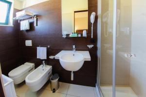 y baño con lavabo, aseo y ducha. en Hotel Taormina, en San Benedetto del Tronto